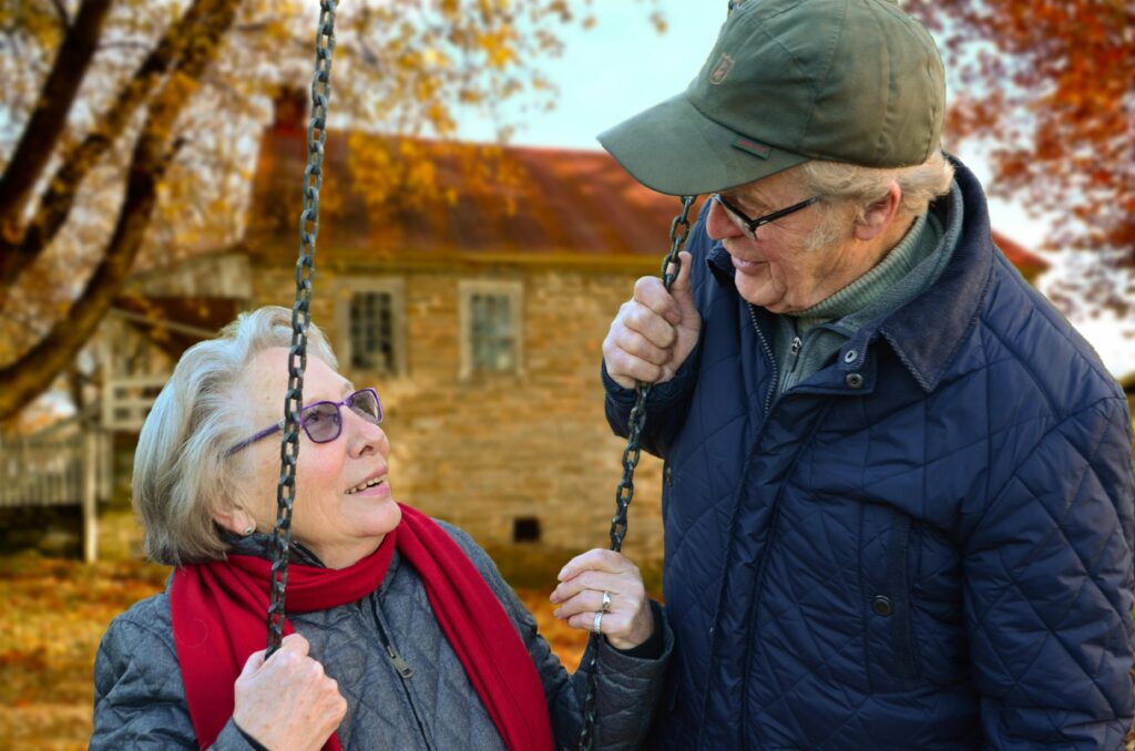 old people couple together connected 34761 A happy elderly couple sharing a joyful moment on a swing in autumn setting.