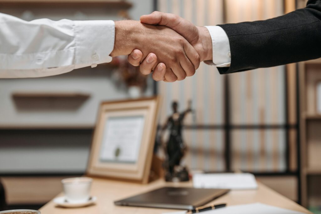 pexels photo 8112172 8112172 Close-up of a handshake between two professionals in a modern office setting, emphasizing partnership and agreement.